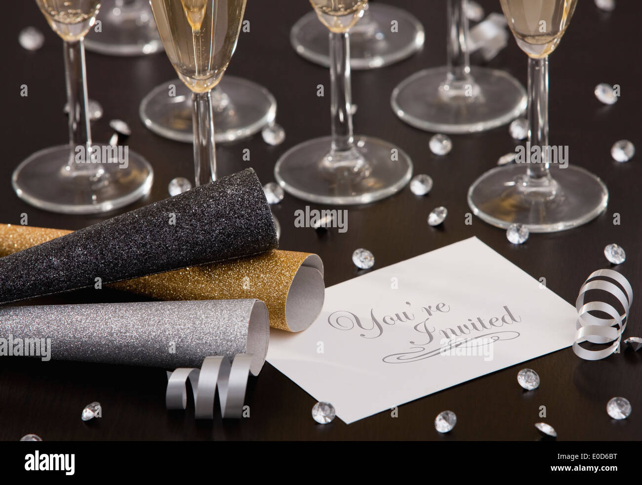 Invitation and champagne flutes on table Stock Photo