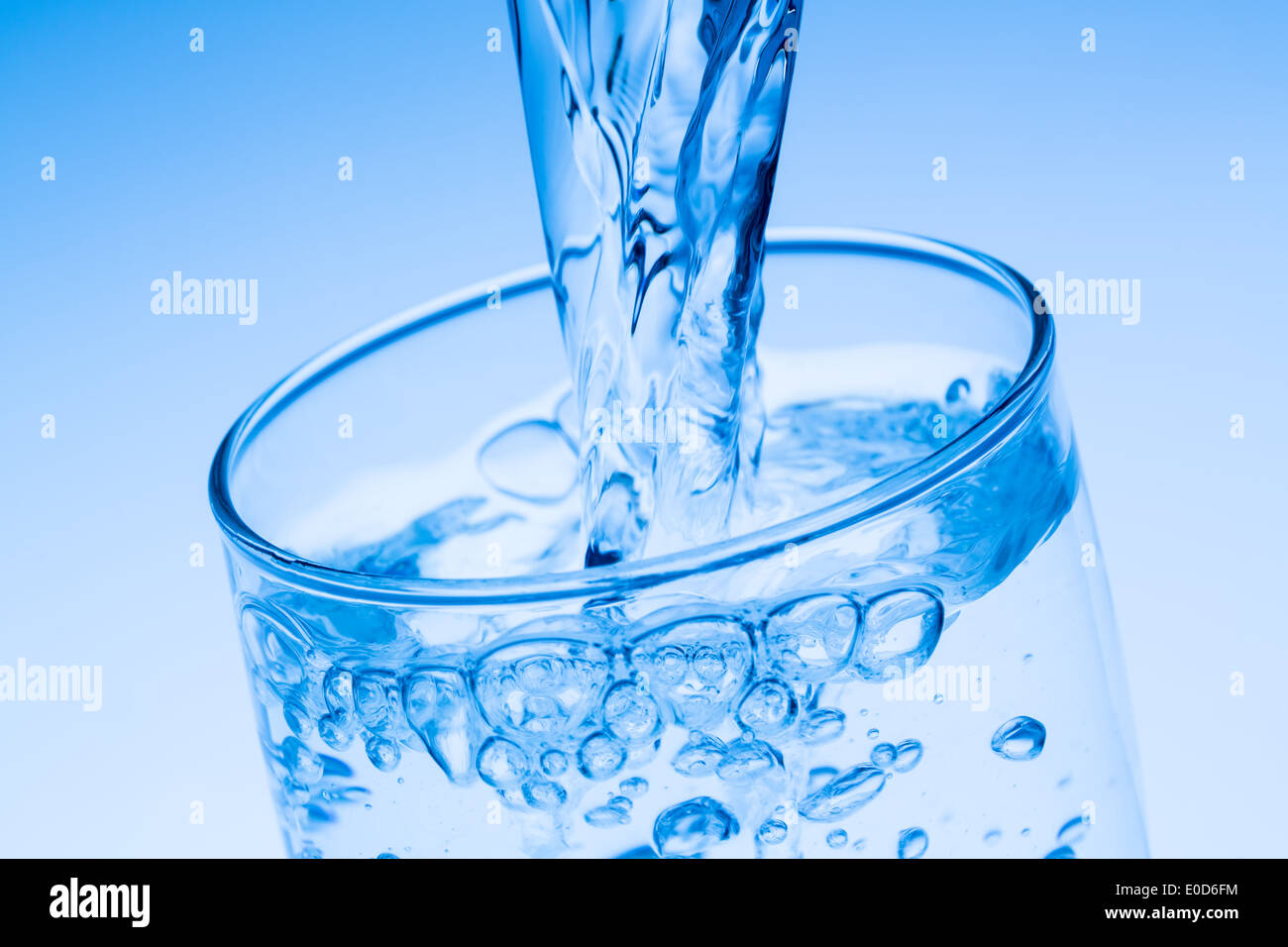Water in a glass gie?ssen, symbolic photo for drinking water, ? ? ? berfluss and waste, Wasser in ein Glas gie?ssen, Symbolfoto Stock Photo