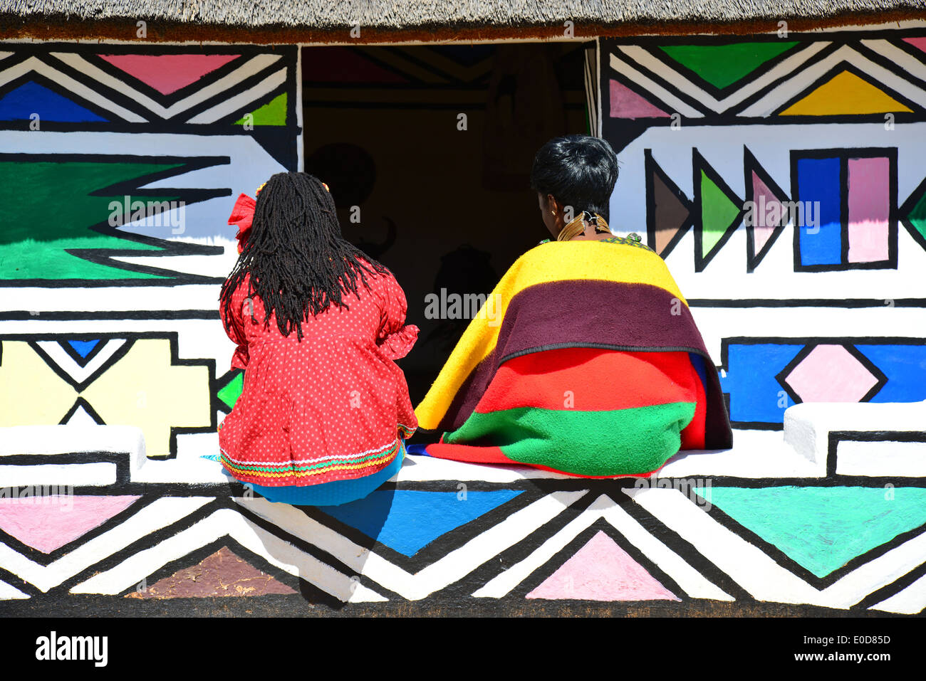 Ndebele women and hut at Motseng Cultural Village, Sun City Resort, Pilanesberg, North West Province, Republic of South Africa Stock Photo
