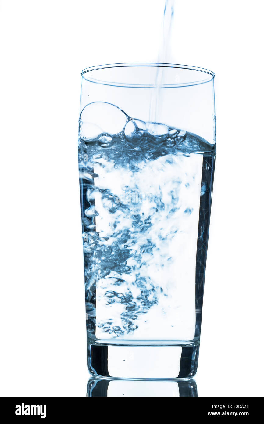 Water is poured in a glass, symbolic photo for drinking water, freshness, need and consumption, Wasser wird in ein Glas gegossen Stock Photo