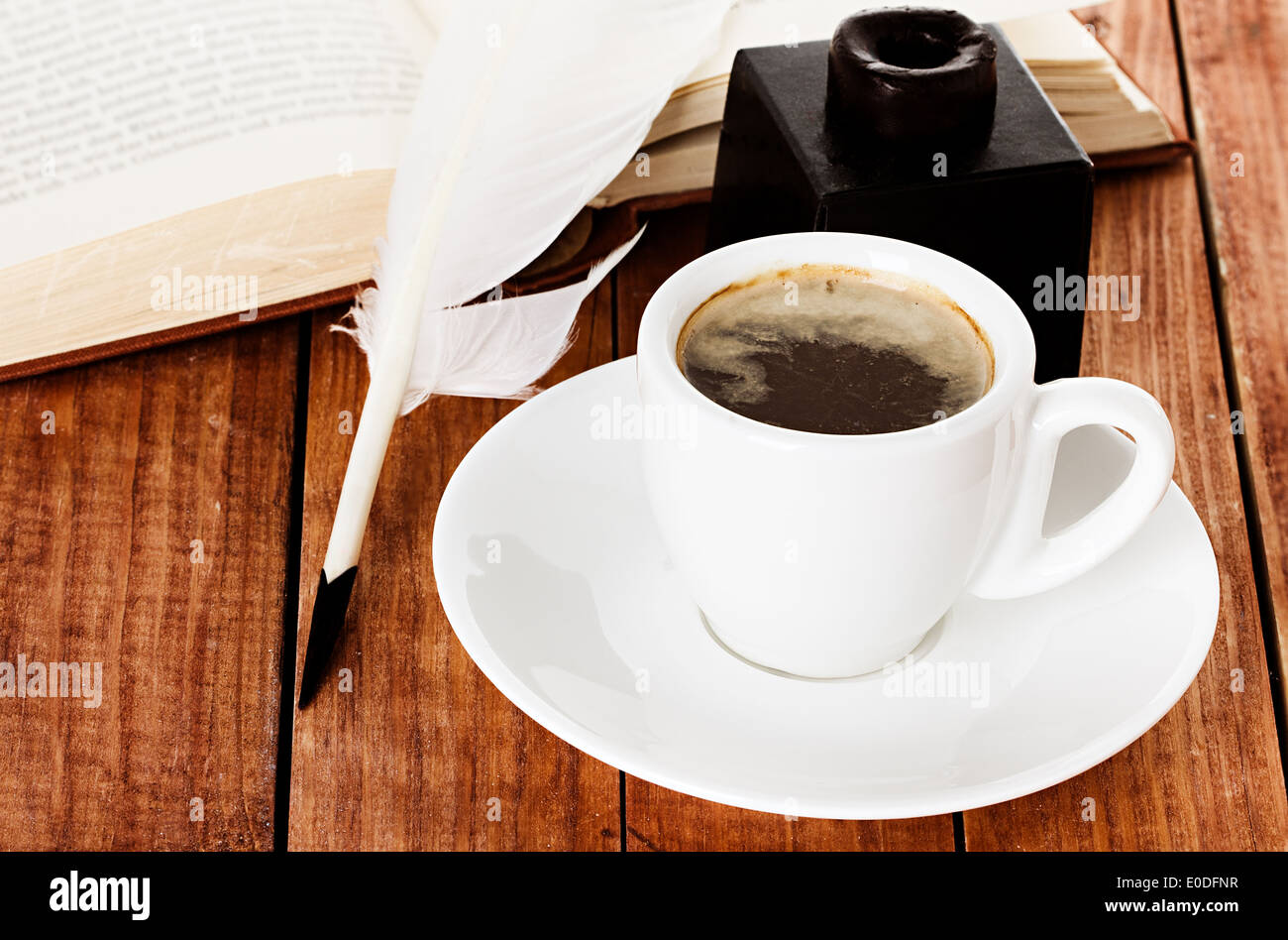 cup of coffee with a quill pen and inkwell on wooden background book Stock Photo
