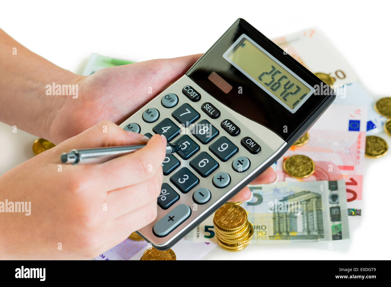 Hand with pocket calculator and bank notes. Symbolic photo for turnover, profit, taxes and calculation, Hand mit Taschenrechner Stock Photo
