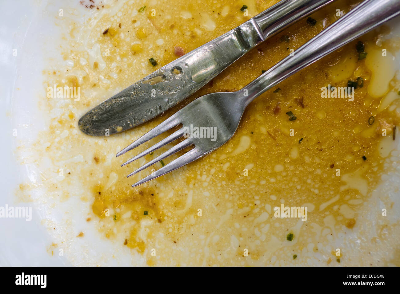 A cutlery lies after food on a plate, Ein Besteck liegt nach dem Essen auf einem Teller Stock