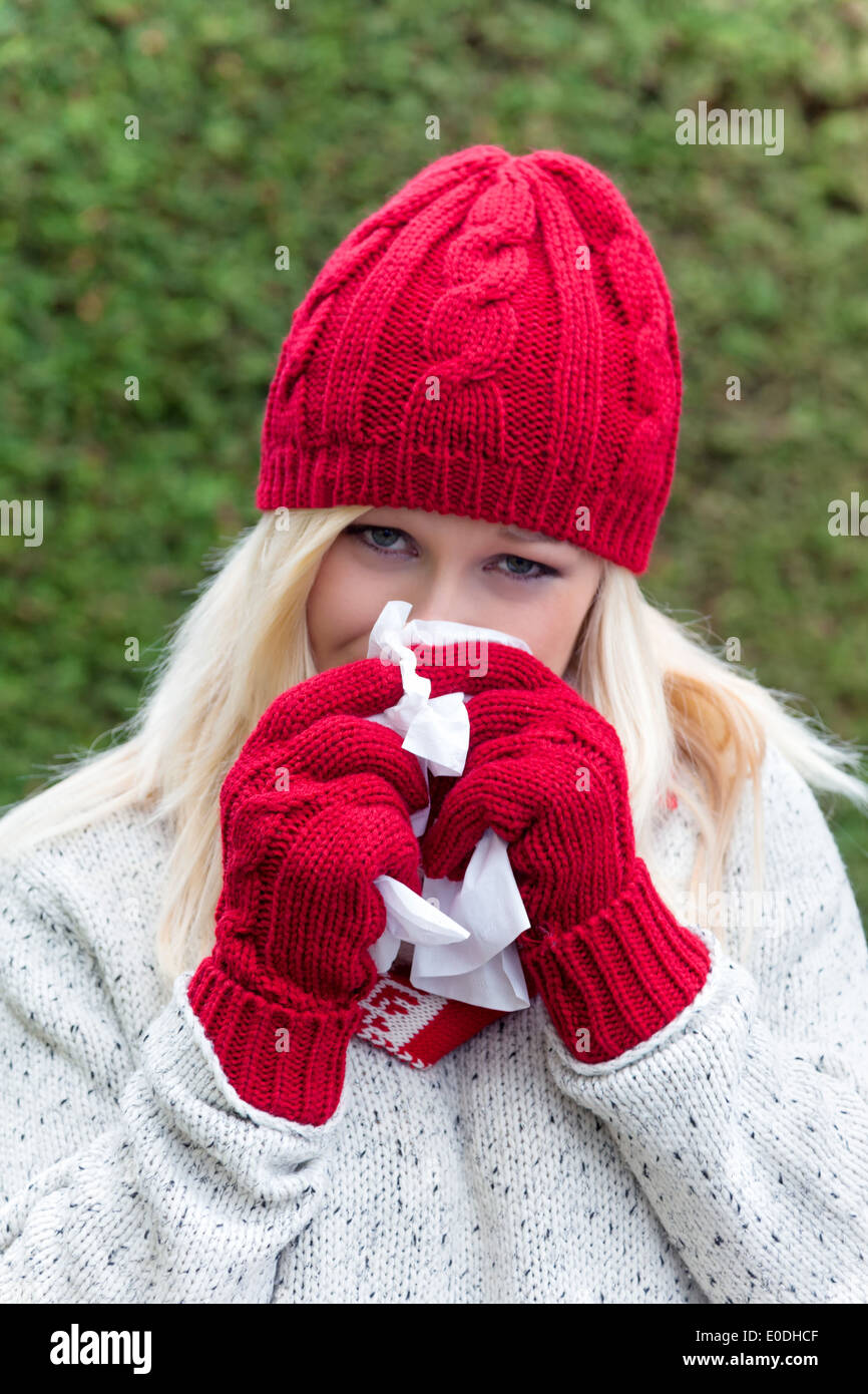 A young woman has a cold and is caught cold. Autumn time is a time for influenza, a cold and cold, Eine junge Frau hat Schnupfen Stock Photo