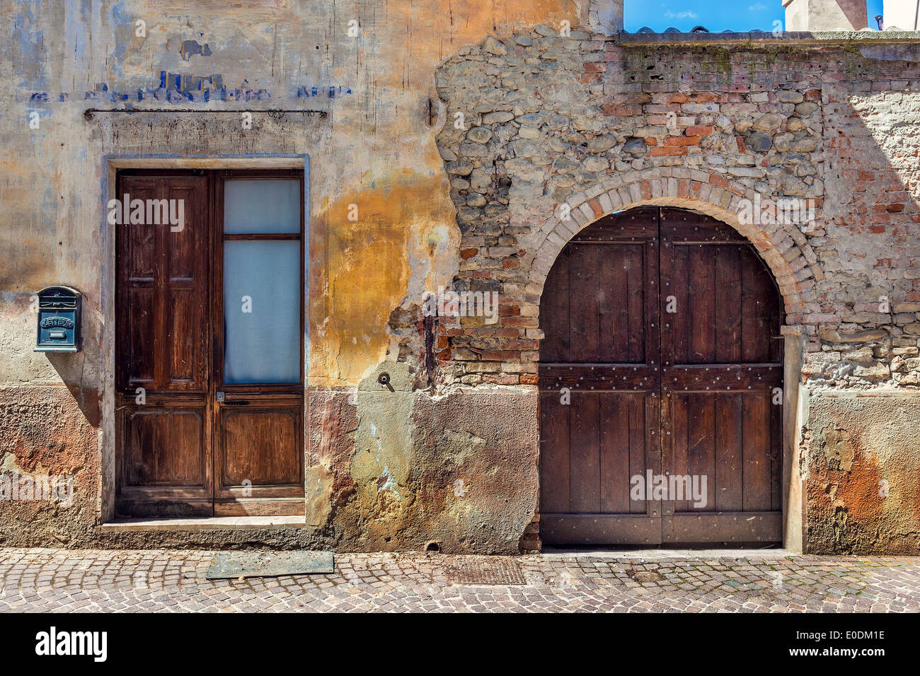 Wooden door, gate and letter box at the entrance to old abandoned brick