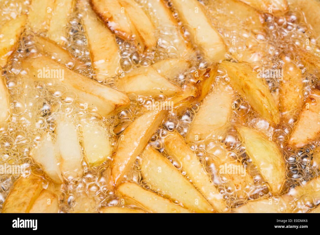 Preparing French Fries In Hot Boiling Oil With Fresh Potato Chips Stock Photo