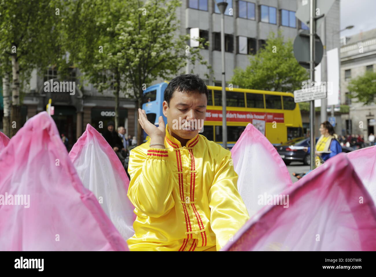 Dublin, Ireland. 10th May 2014. A Falun Dafa practitioner sits in an large artificial flower, practicing Falun Dafa meditations during the procession to celebrate World Falun Dafa Day in Dublin. Falun Dafa is calling for an end of the persecution of Falun Dafa by the Chinese government. Credit:  Michael Debets/Alamy Live News Stock Photo
