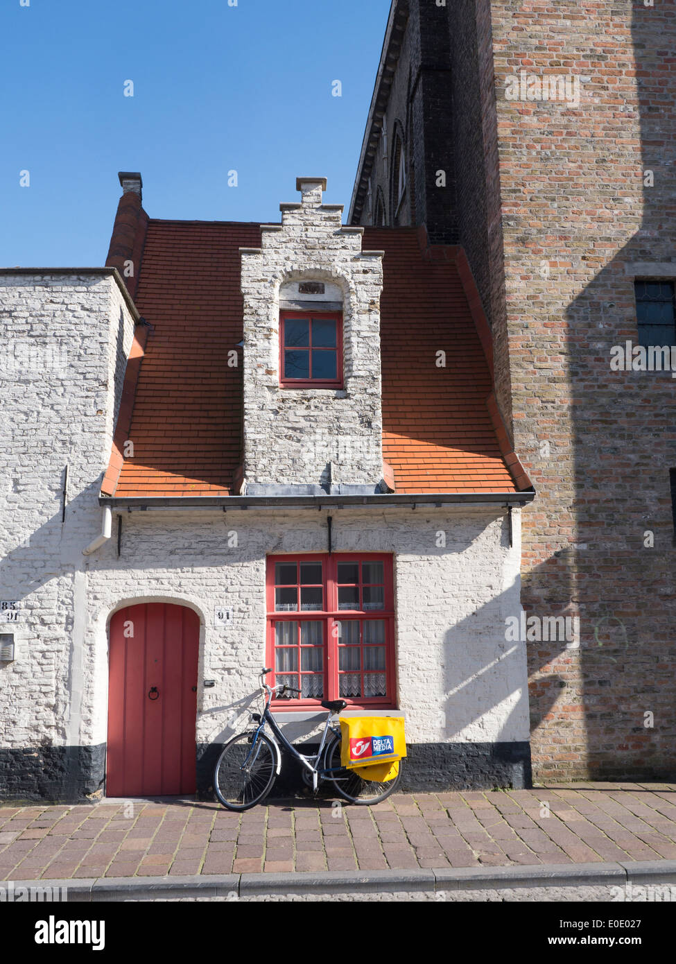 Delivery bicycle parked outside a typical old building in Bruges, belgium Stock Photo