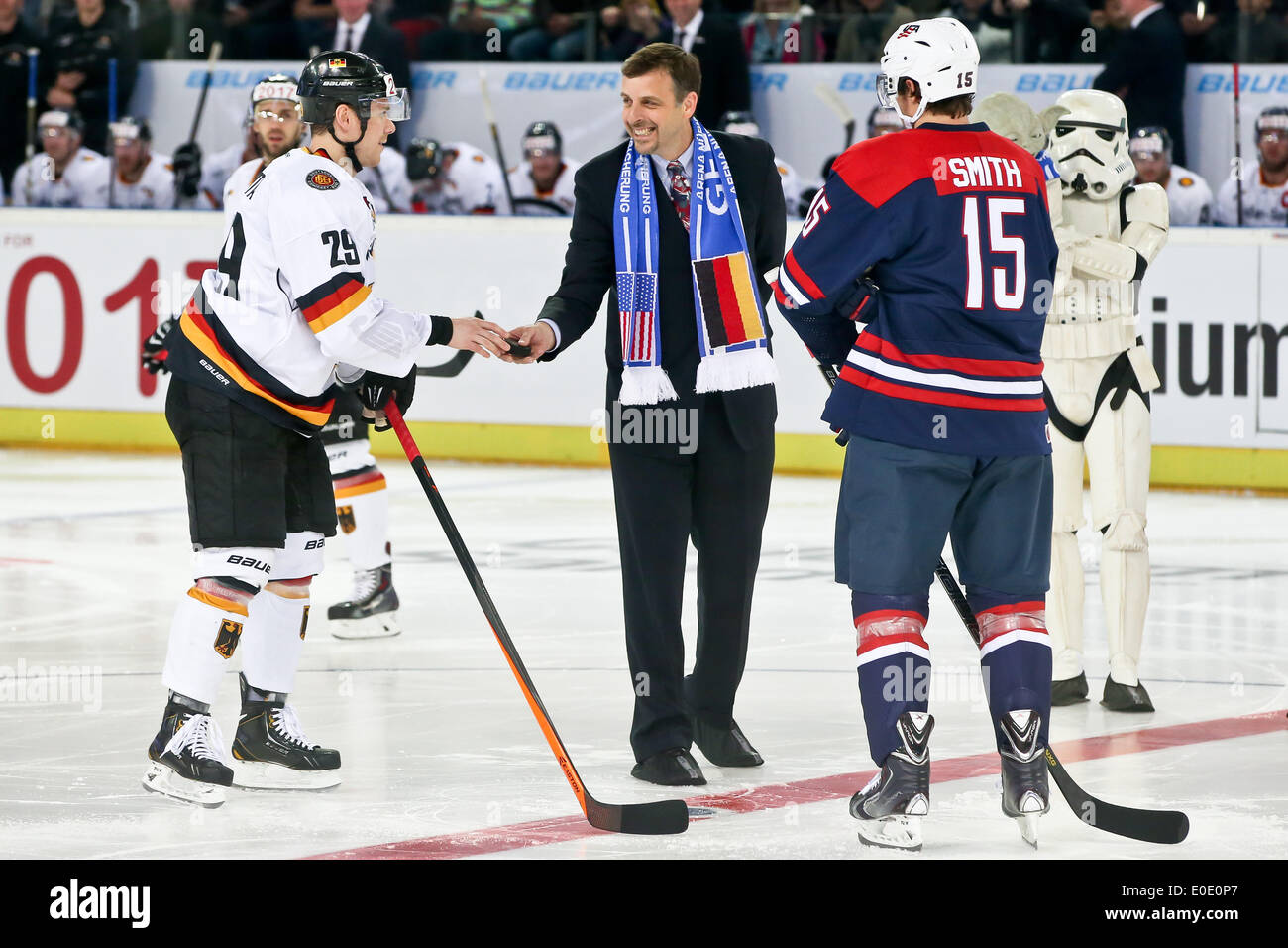 Nuremberg, Germany. 06th May, 2014. American consul general in Munich Bill Moeller (2-L) holds the puck next to Germany's Alexander Barta (L) and USA's Craig Smith during the world ice hockey championship preparation match between Germany and the USA at Arena Nuernberg in Nuremberg, Germany, 06 May 2014. A storm trooper from Star Wars stands to the right with a Yoda figure on its arm. Photo: Daniel Karmann/dpa/Alamy Live News Stock Photo