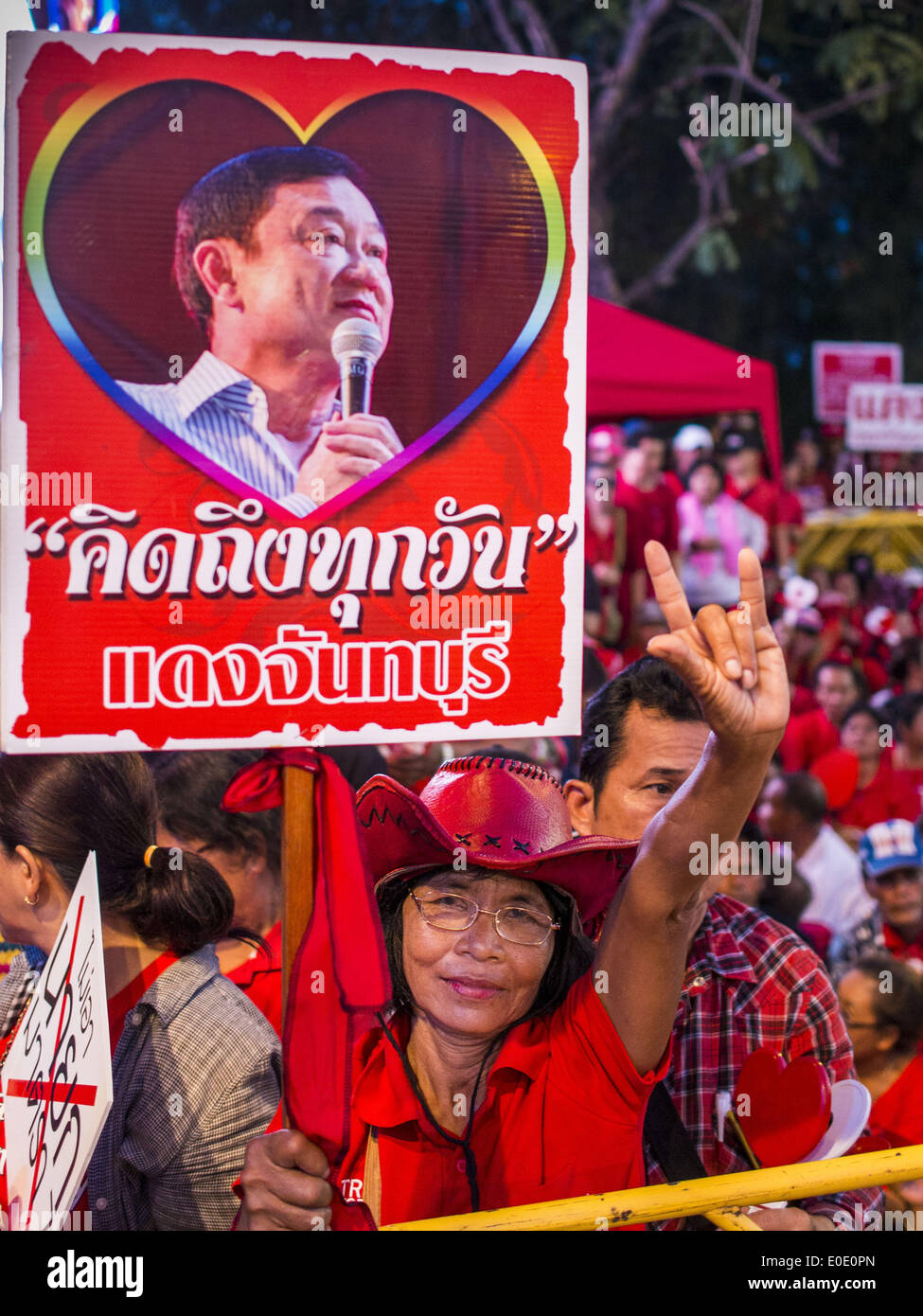 Bangkok, Thailand. 10th May, 2014. A Red Shirt supporter with a photo of ousted and exiled former Prime Minister Thaksin Shinawatra cheers for ousted Prime Minister Yingluck Shinawatra (Yingluck is Thaksin's sister) at a rally in Bangkok. Thousands of Thai Red Shirts, members of the United Front for Democracy Against Dictatorship (UDD), members of the ruling Pheu Thai party and supporters of the government of ousted Prime Minister Yingluck Shinawatra are rallying on Aksa Road in the Bangkok suburbs. Credit:  ZUMA Press, Inc./Alamy Live News Stock Photo
