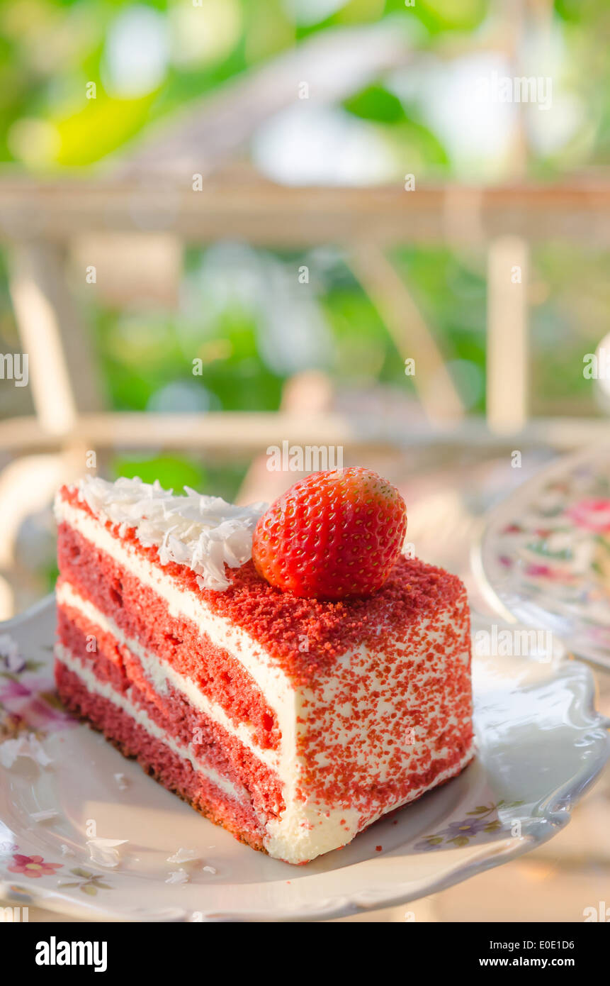 Piece of fruit cake with fresh strawberry on dish Stock Photo