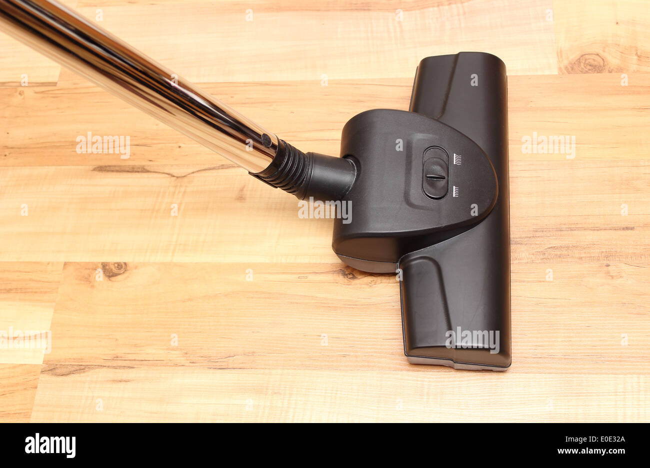 Closeup of head of modern vacuum cleaner on wooden floor background Stock Photo