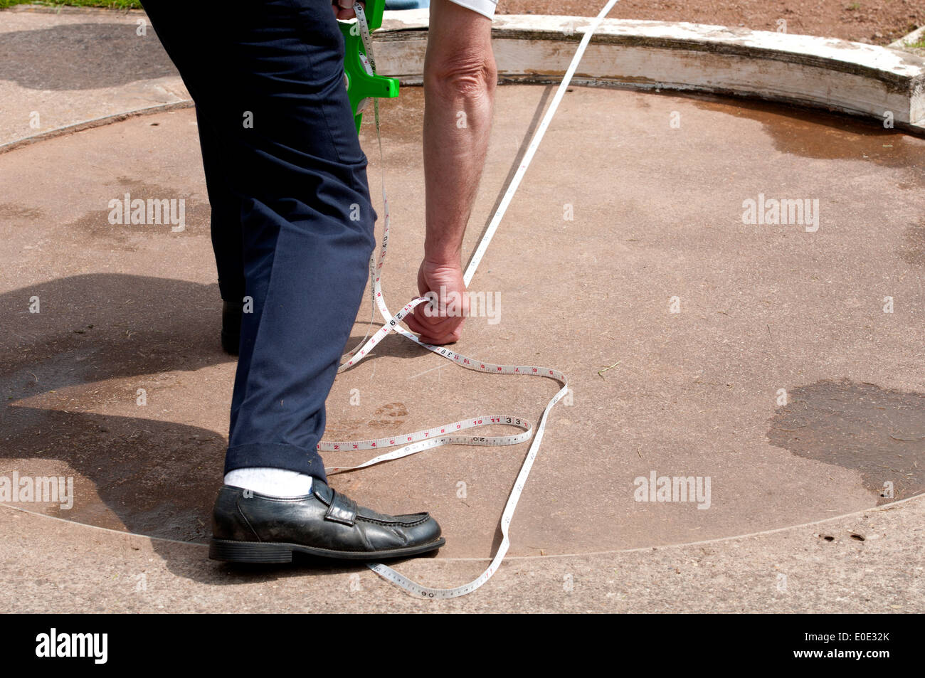 https://c8.alamy.com/comp/E0E32K/athletics-official-measuring-shot-put-throw-E0E32K.jpg