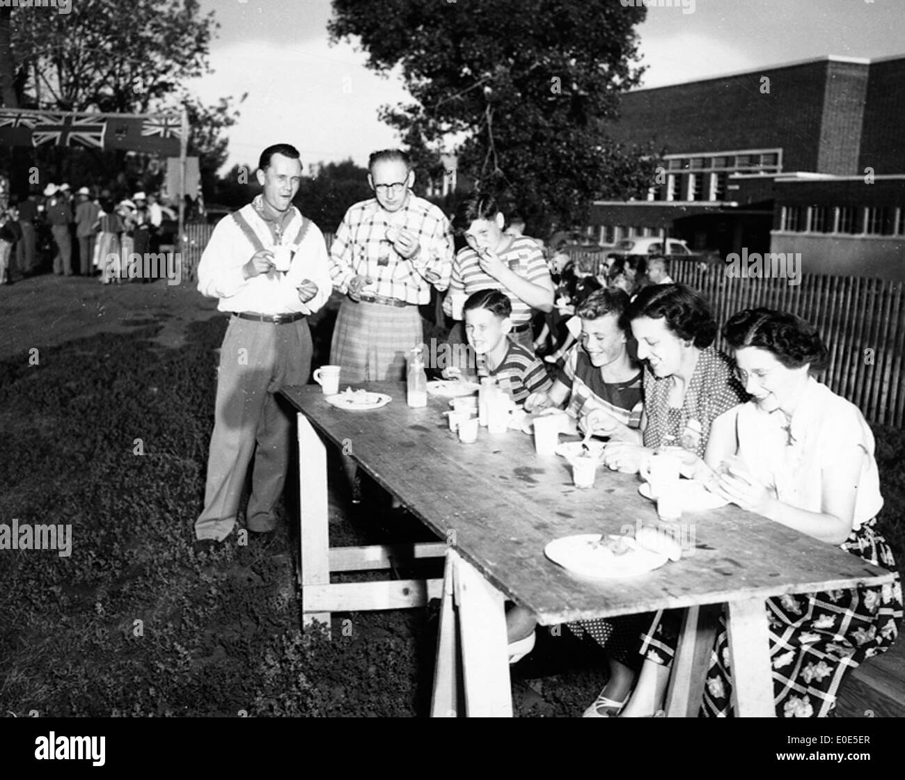 61. Do you know this family sitting at a table on the grounds of the Fritz Sick Centre? SOLVED! Stock Photo