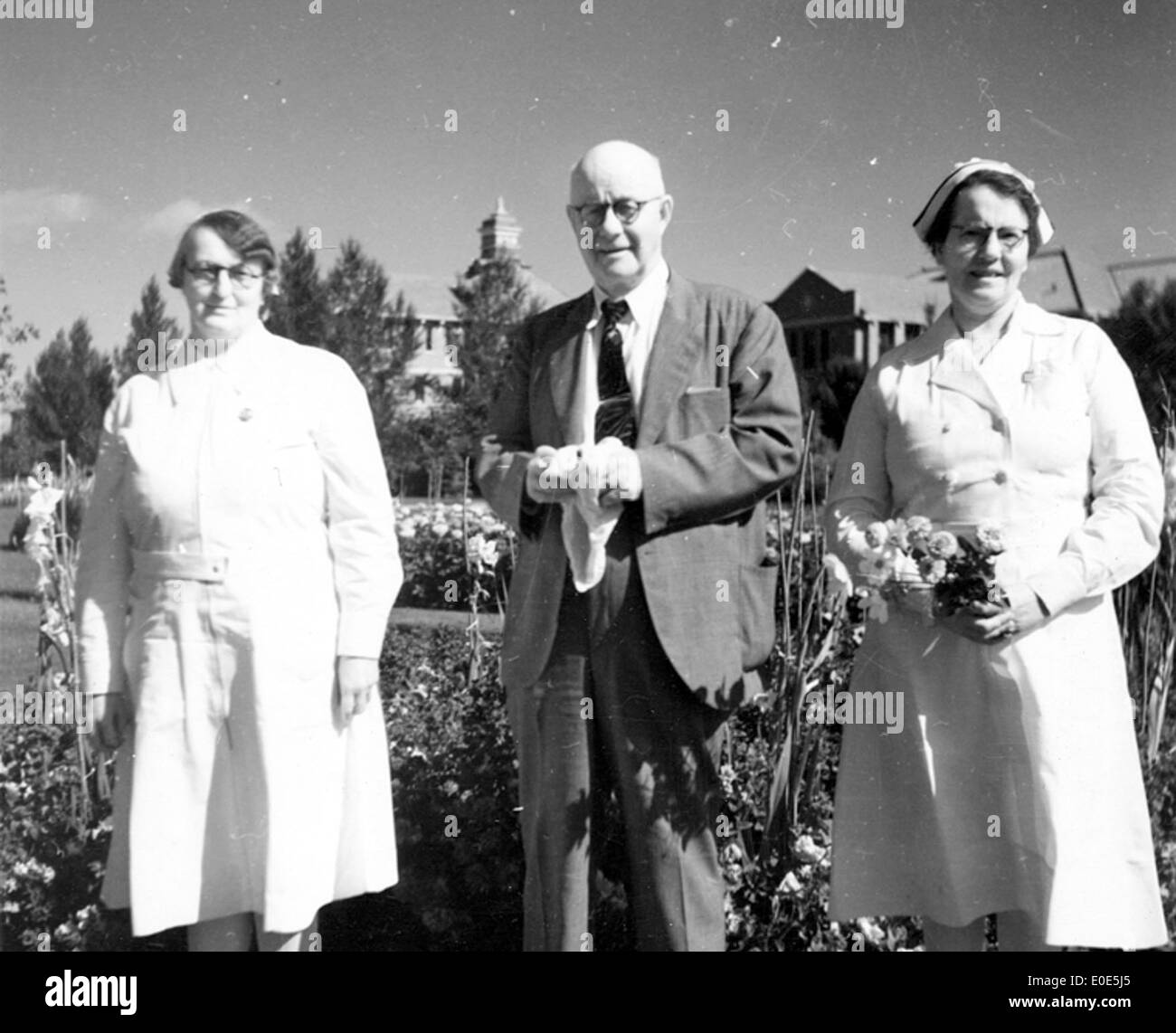 24. Who are these nurses and gentleman in flower garden? Stock Photo