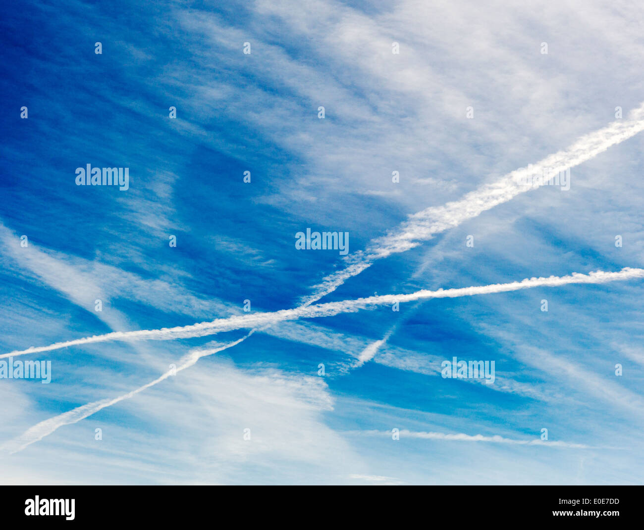 Jet contrails cross against a clear azure blue Colorado sky Stock Photo