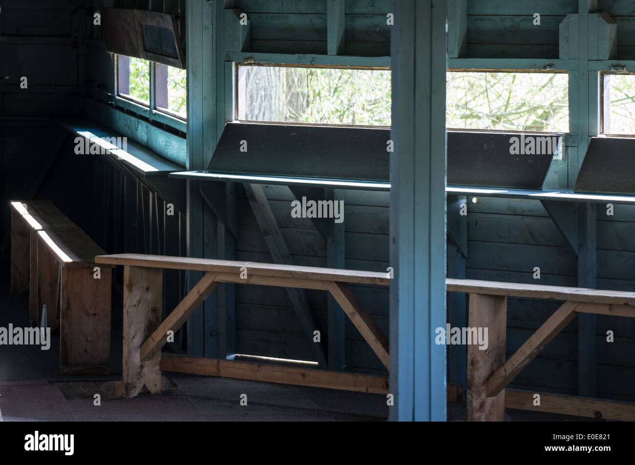 benches and windows inside a bird hide Stock Photo