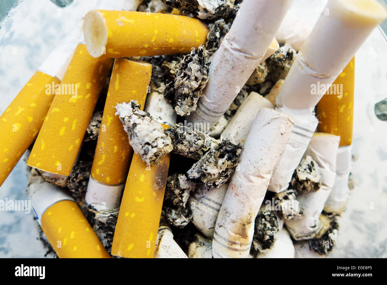 Many springs of cigarettes lie in an ashtray., Viele Kippen von Zigaretten liegen in einem Aschenbecher. Stock Photo