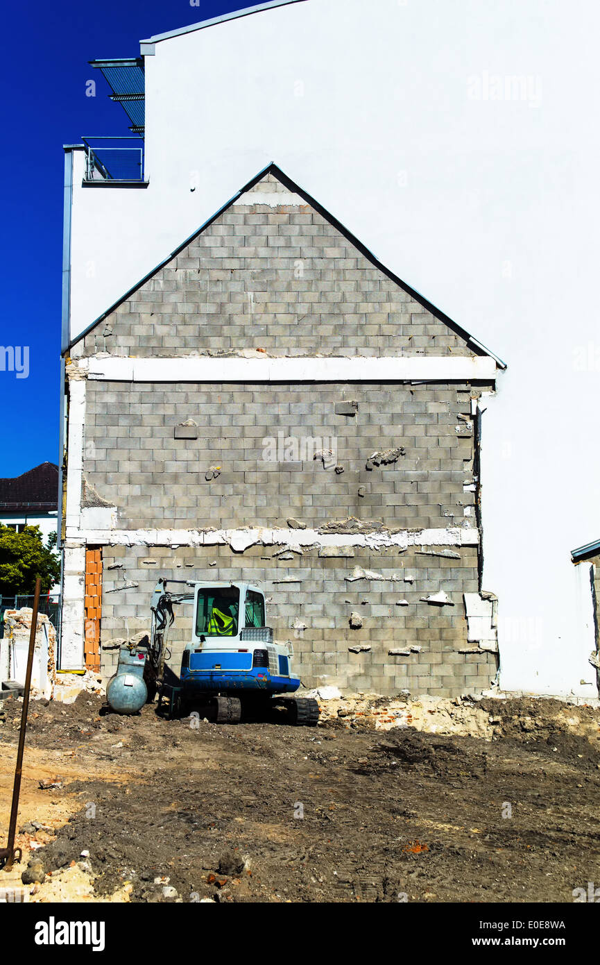 A dwelling house was torn off. Excavator on a building site, Ein Wohnhaus wurde abgerissen. Bagger auf einer Baustelle Stock Photo