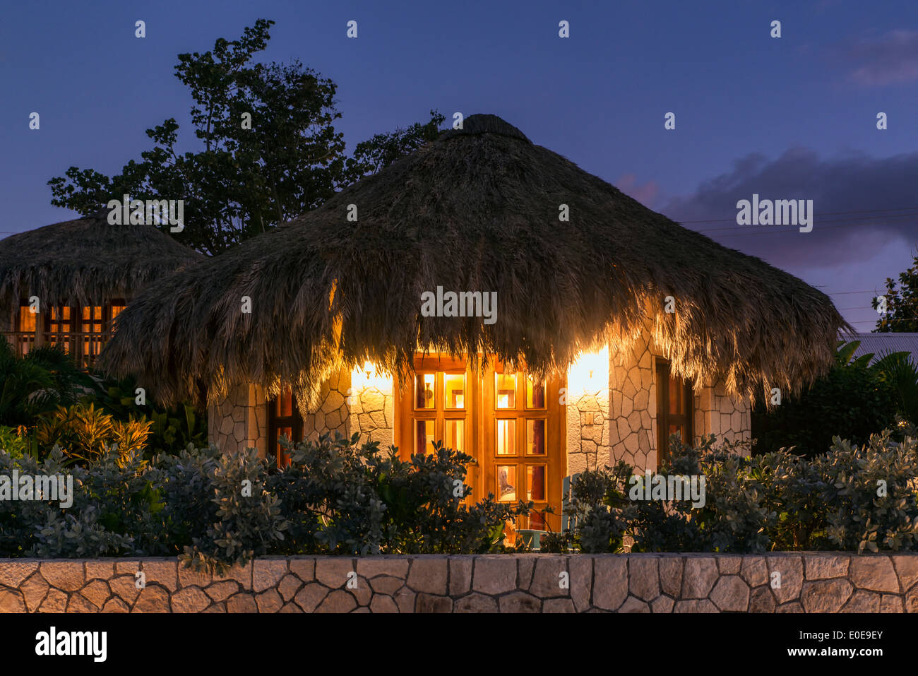 Boutique hotel cottages with thatched roof at night, Negril, Jamaica Stock Photo