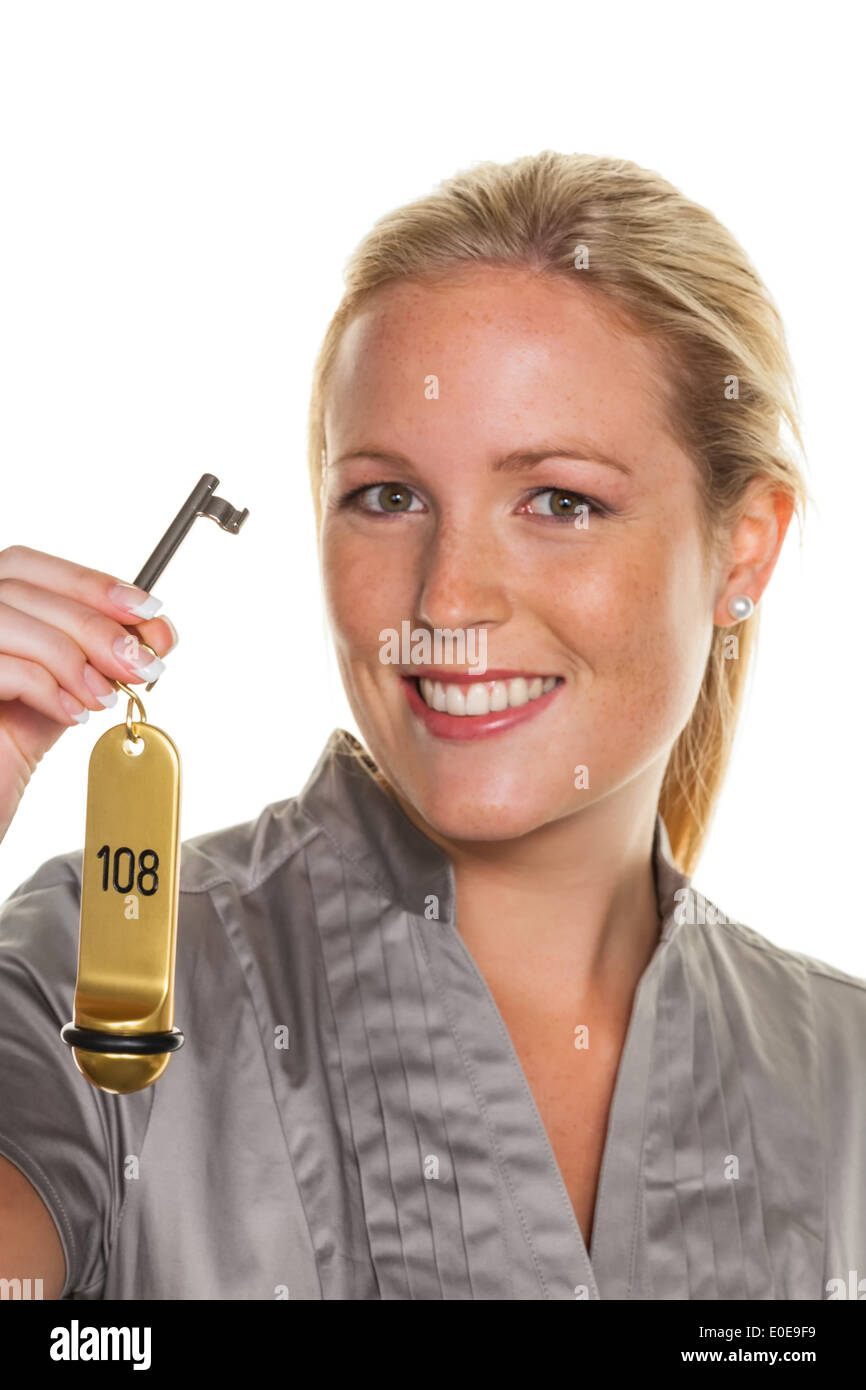 A young woman holds the key of a hotel room Stock Photo