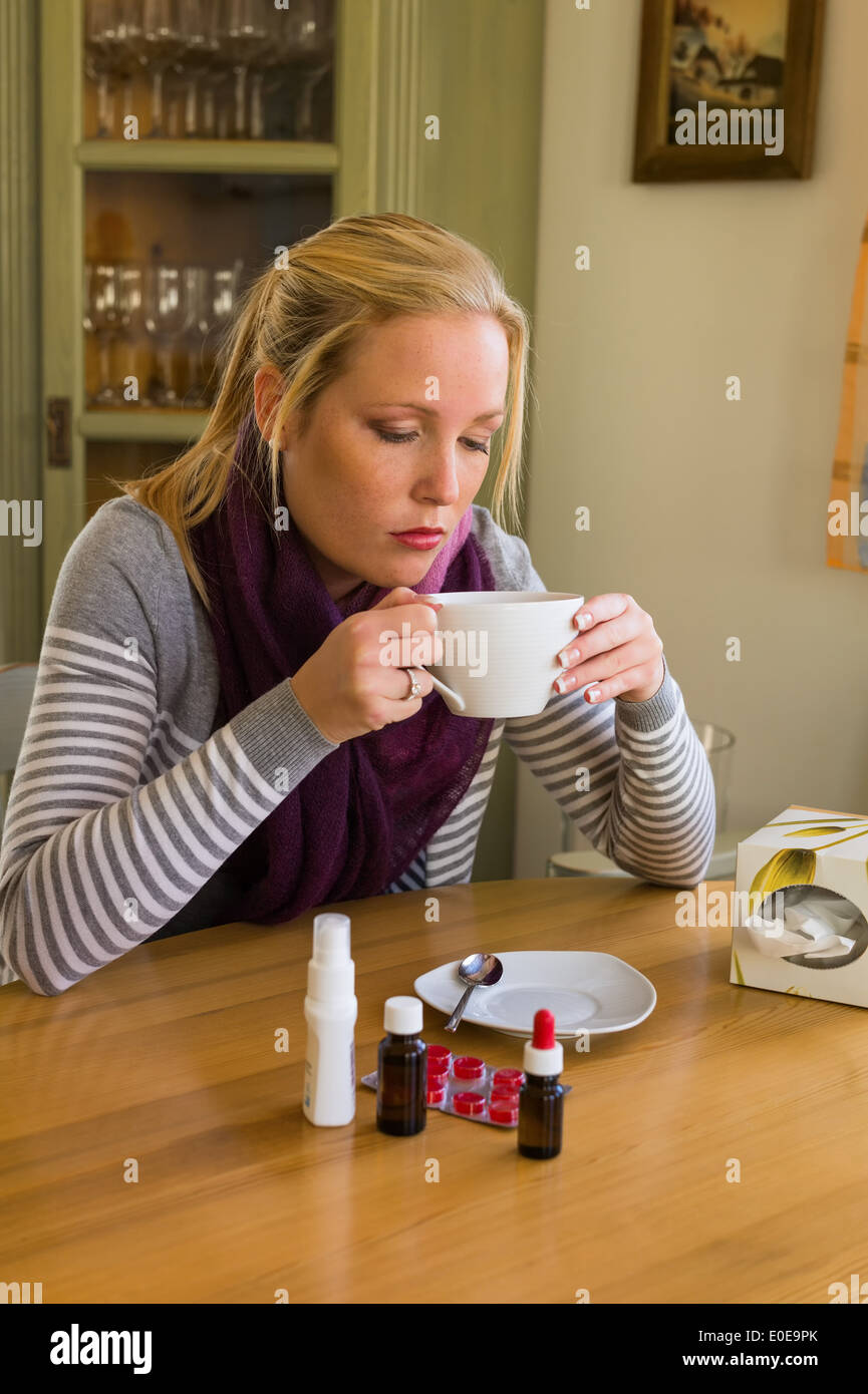 Woman in the sick person's state with tea and drugs Stock Photo