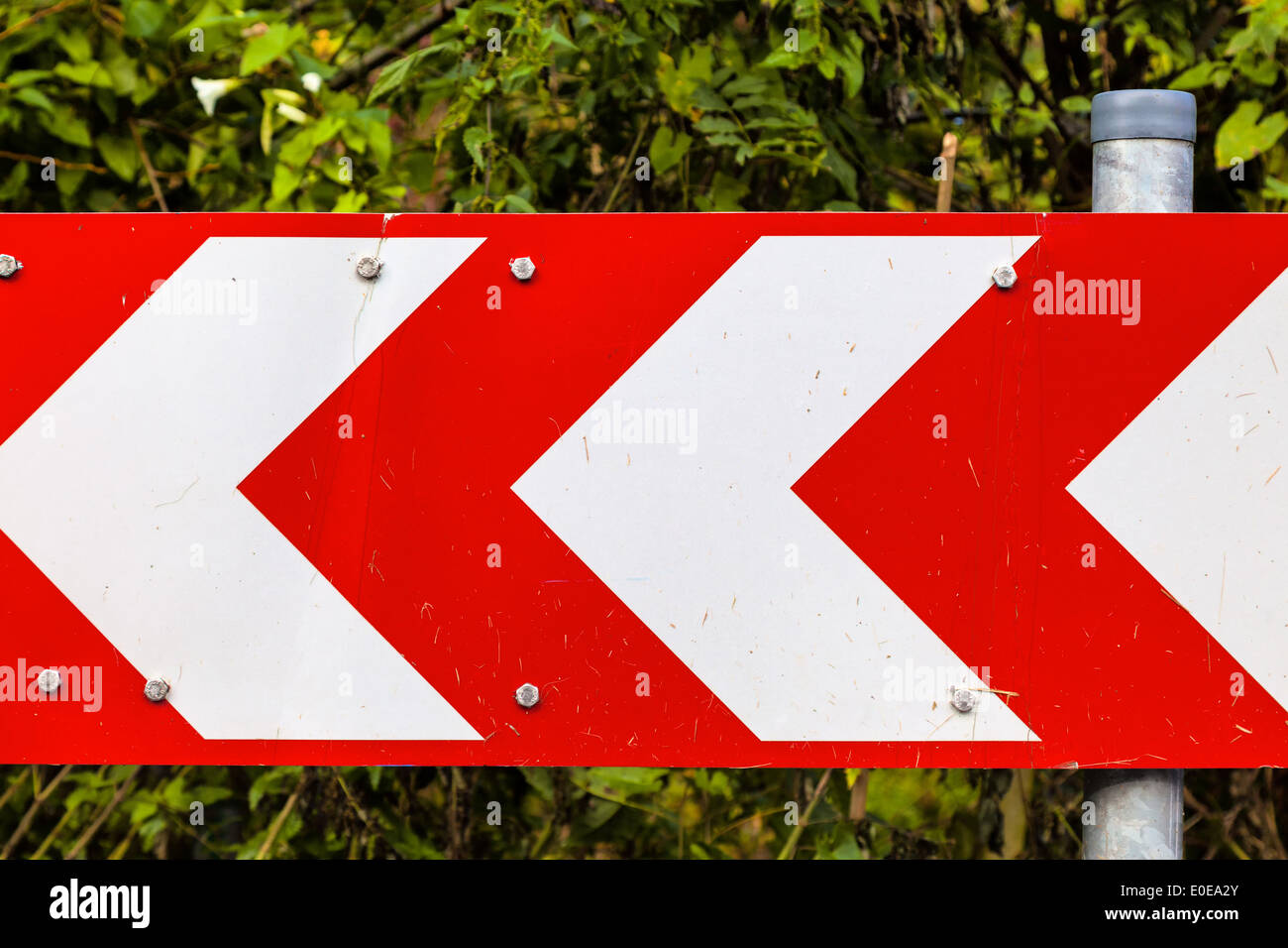 A red-white direction arrow of a street mark, Ein rot-weisser Richtungspfeil einer Strassenmarkierung Stock Photo