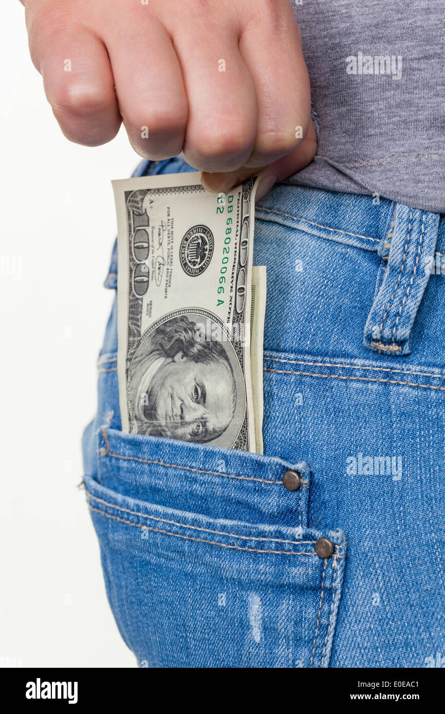 The hand of a young woman pulls a dollar of bank note from the pocket of her jeans, Die Hand einer jungen Frau zieht einen Dolla Stock Photo