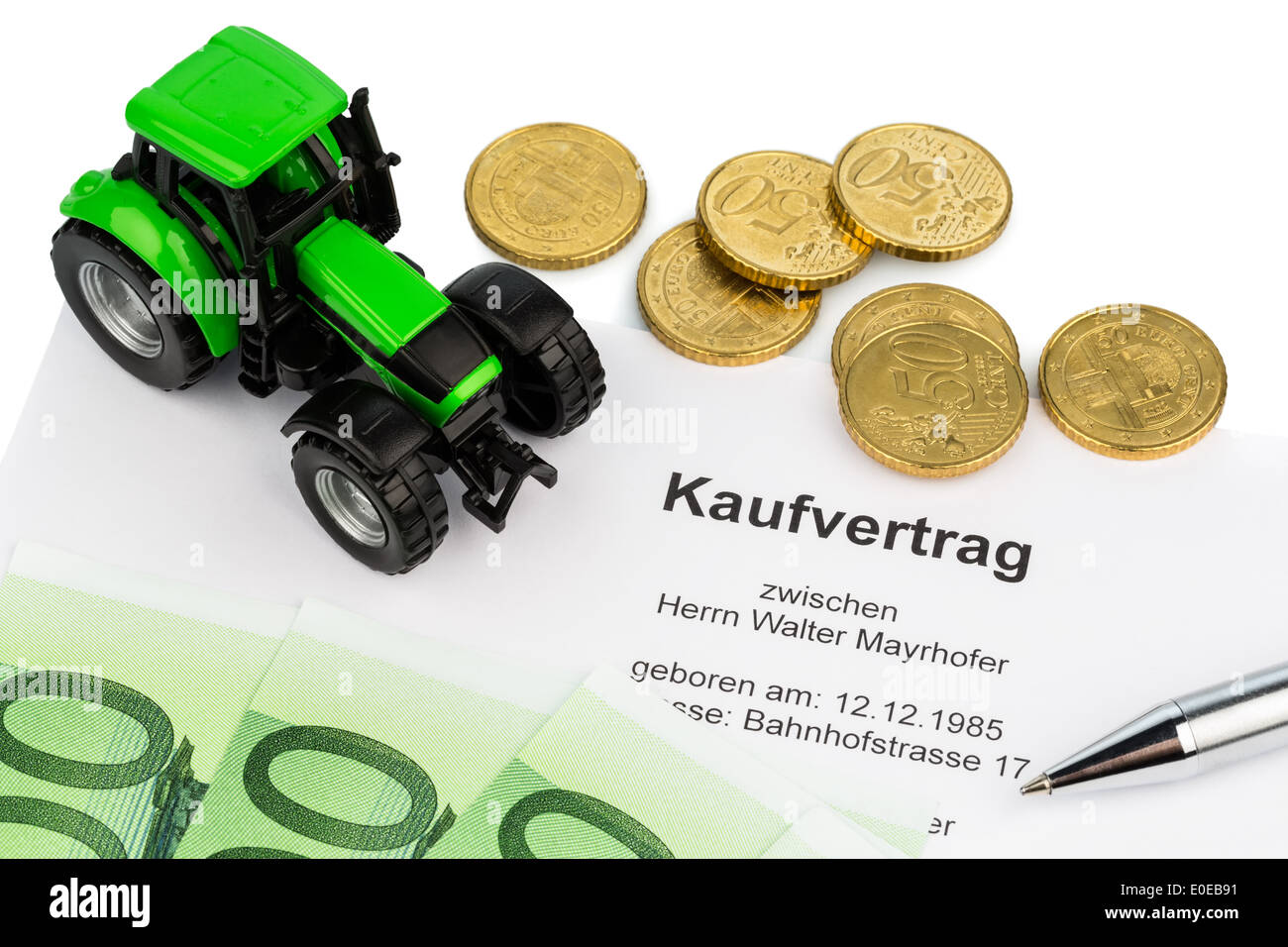 The bill of sale for a new tractor with a car dealer. With eurobank notes., Der Kaufvertrag fuer einen neuen Traktor bei einem A Stock Photo