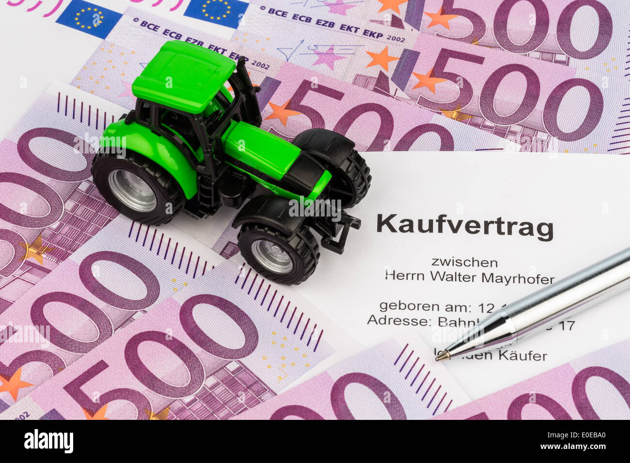 The bill of sale for a new tractor. With euromoney and ballpoint pen, Der Kaufvertrag fuer einen neuen Traktor. Mit Eurogeld und Stock Photo