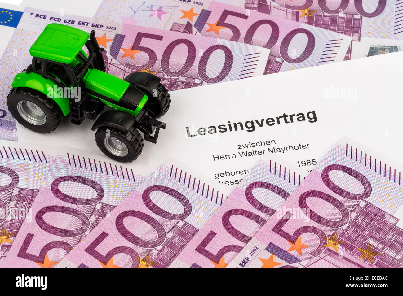 The leasing contract for a new tractor. With euromoney and ballpoint pen, Der Leasingvertrag fuer einen neuen Traktor. M Stock Photo