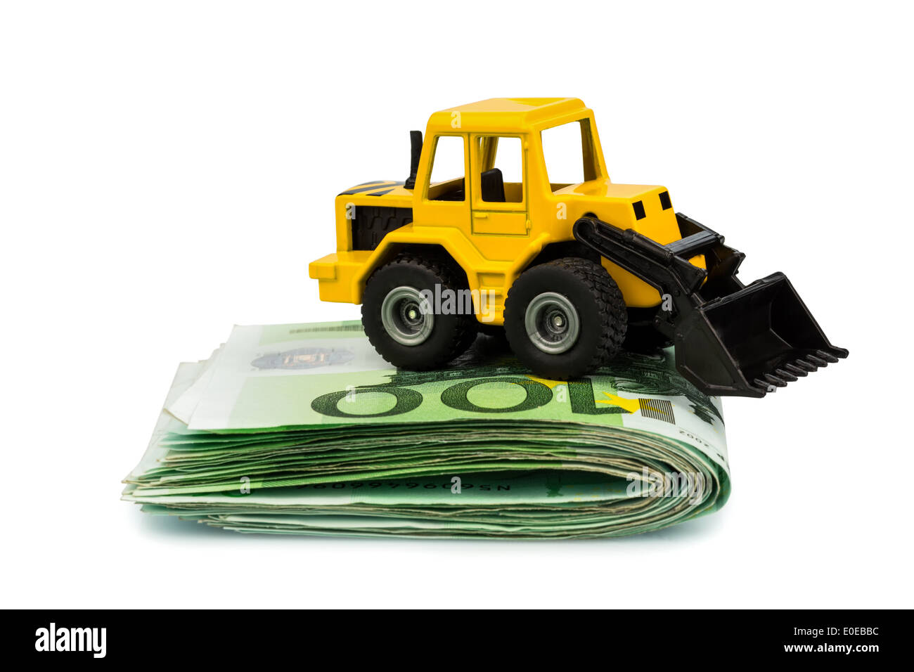 An excavator stands on eurobank notes. Symbolic photo for costs, yields and supports in the building trade and the building indu Stock Photo