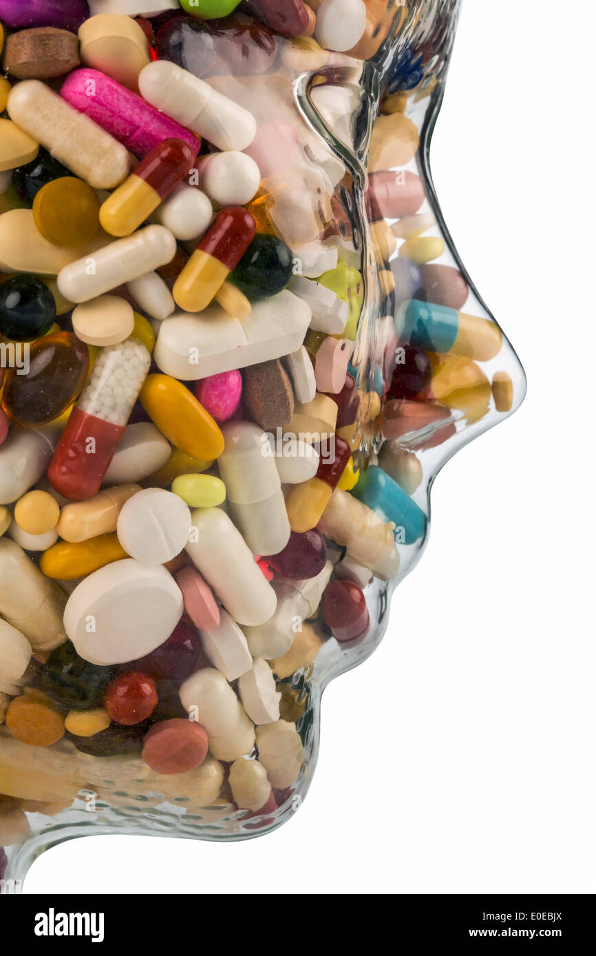 A head of glass with many tablets full. Symbolic photo for drugs, abuse and tablet addiction., Ein Kopf aus Glas mit vielen Tabl Stock Photo