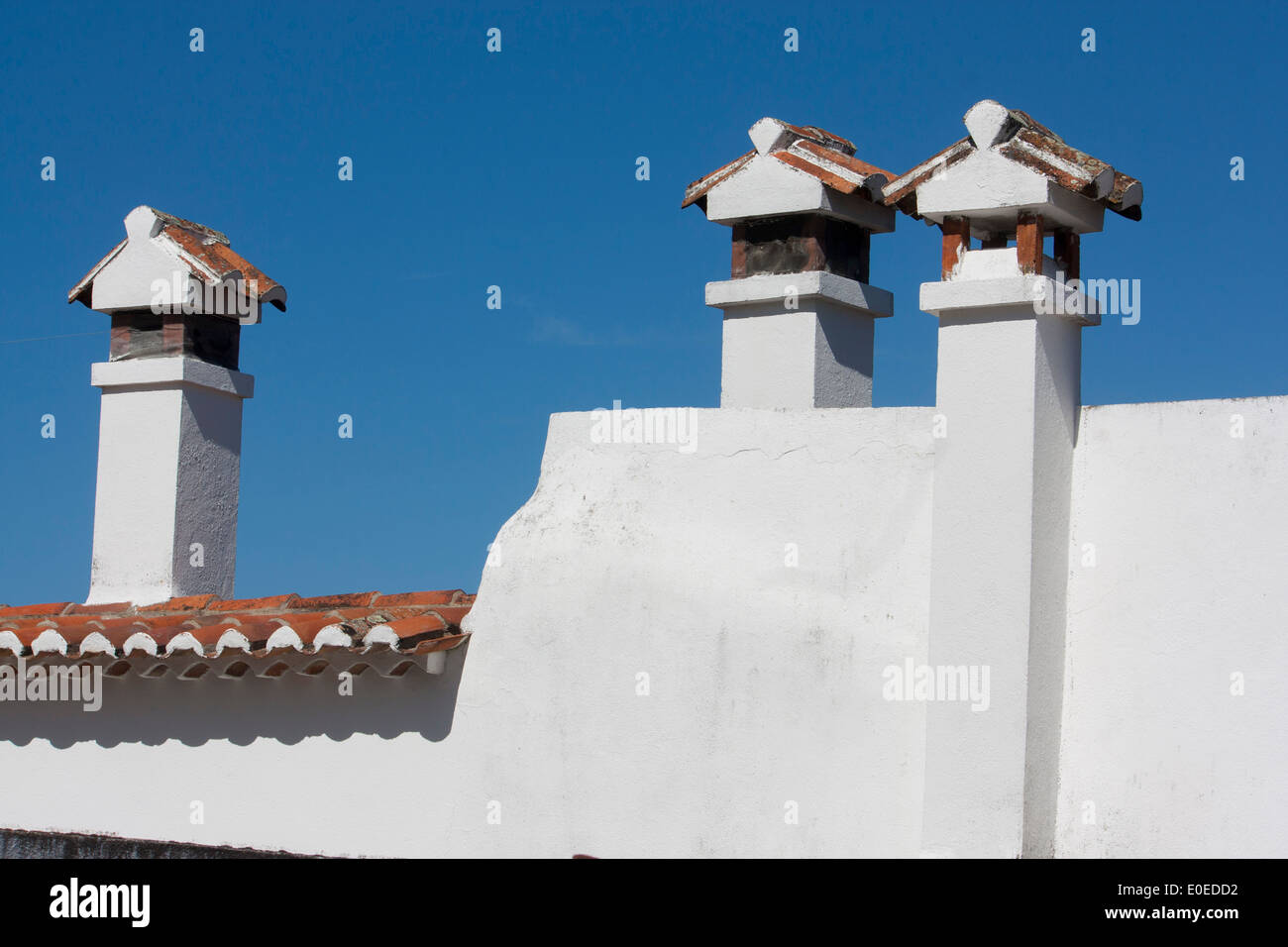 Traditional chimneys on white painted houses with terracotta roof tiles Marvao Alentejo Portugal Stock Photo