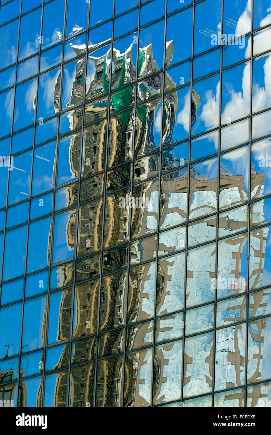 Abstract, distorted image of a building reflected in the windows of a tall city building Stock Photo