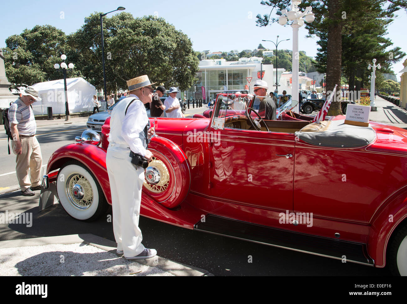 Man viewing a red American Packard Super 8 classic car during the Art Deco weekend in Napier North Island New Zealand 2014 Stock Photo