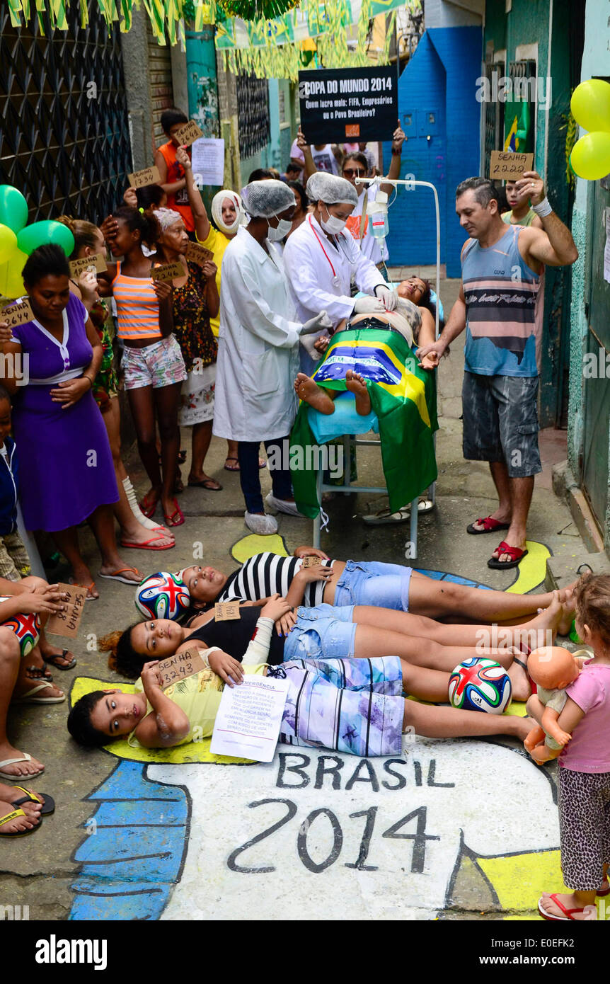 Rio De Janeiro, Brazil. 10th May, 2014. Residents participate in a protest at Jacarezinho community, in Rio de Janeiro, Brazil, on May 10, 2014. Community locals held a pacific protest emulating the poor attention for patients at public hospitals in the country. The protestors demand investment on public health as well as the remodeling labor for Jornalista Mario Filho Stadium, better known as 'Maracana', acording to local press. Credit:  Glaucon Fernandes/Eleven/AGENCIA ESTADO/Xinhua/Alamy Live News Stock Photo