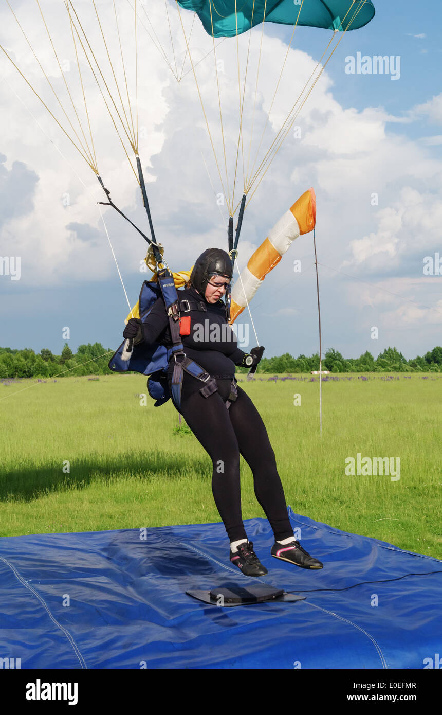One day with parachutist in airfield. The girl skydiver landing under