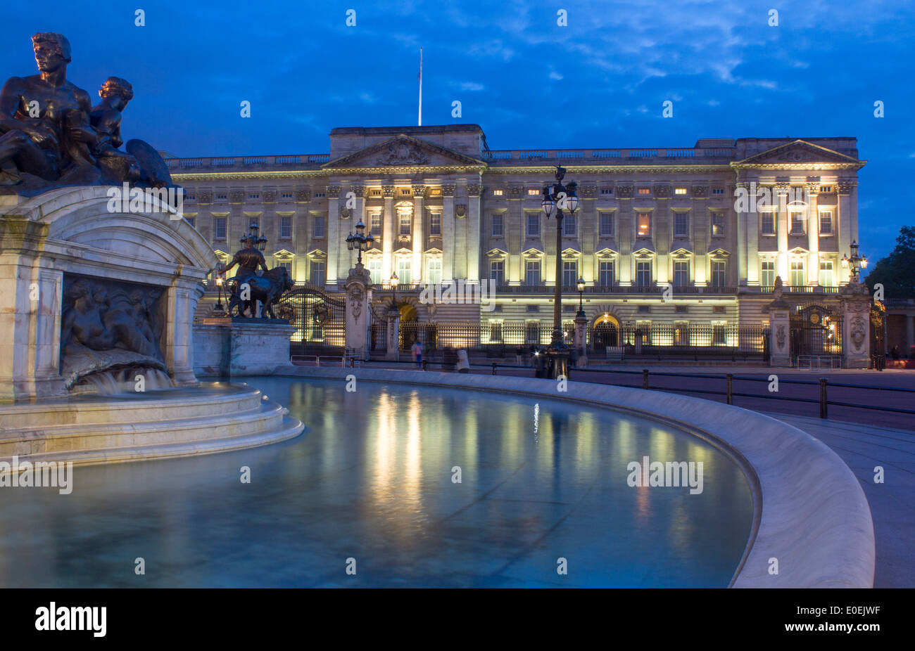 Buckingham Palace at night with Victoria Memorial statues reflected in
