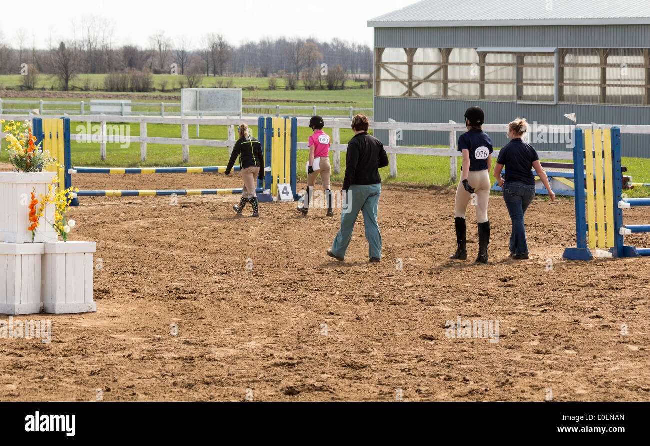 Five women riders walking a jumping course before their jumping class