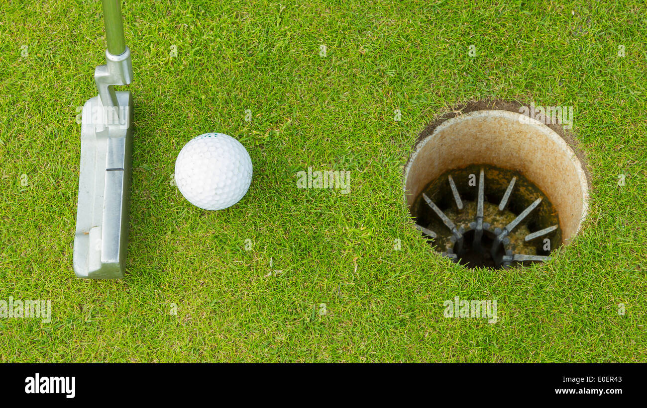 Golf ball and tee on green course in front of driver Stock Photo Alamy