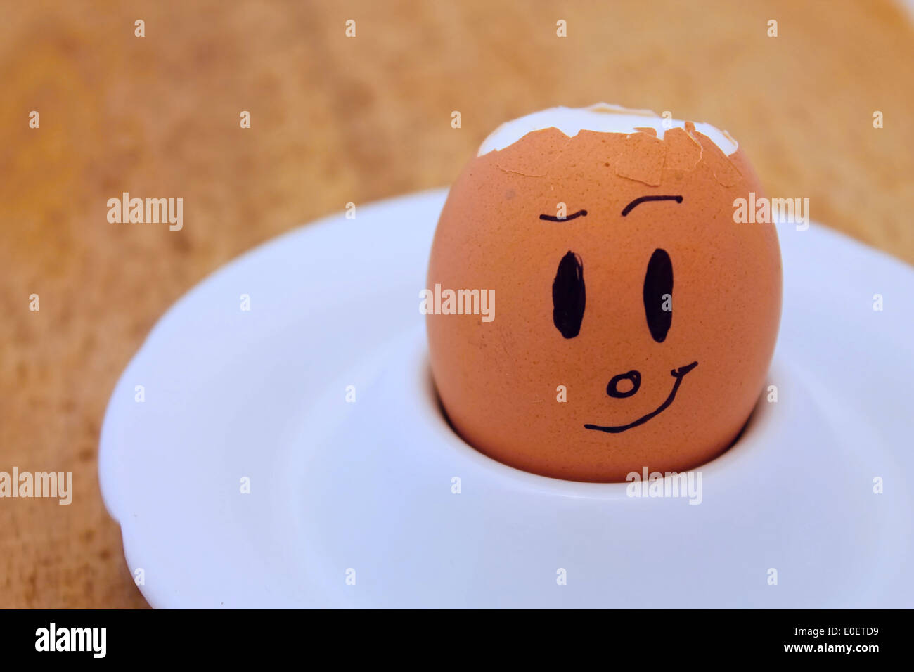 Egg with broken shell and drawn face Stock Photo