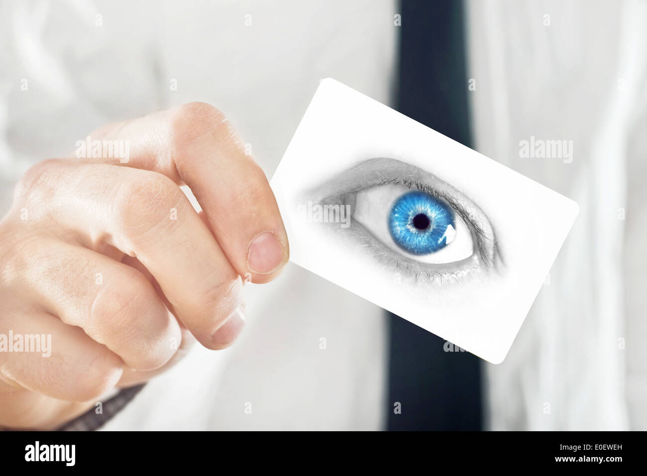 Ophthalmologist giving his visiting card, selective focus on fingers and card Stock Photo