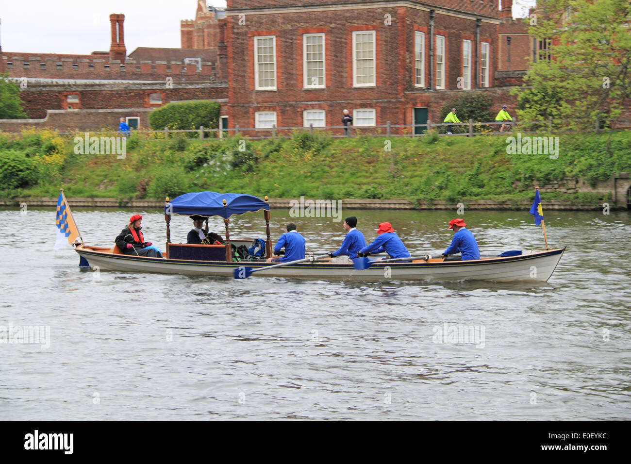 Tudor Pull.  Hampton Court Palace, East Molesey, Surrey, UK. 11th May, 2014. Annual traditional rowing event between the Historic Royal Palaces of Hampton Court and the Tower of London. Thames cutters, here crewed by the Worshipful Company of Scientific Instrument Makers, escort the Royal Barge Gloriana as she delivers a 'Stela' to the Governor of the Tower. This 'Stela' is a piece of ancient water pipe made from a hollowed tree trunk which stands on a base of timber from the old Richmond Lock and bears the coat of arms of the Worshipful Company of Watermen and Lightermen. Stock Photo