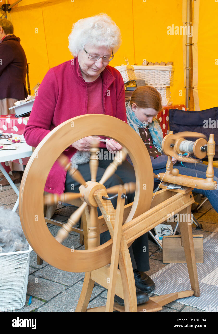 Mary Gravenor operating spinning wheel at Darlington Arts Festival north east England UK Stock Photo