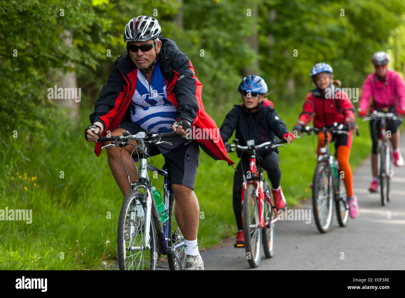 People on the bicycle path,  trail children ride a bike helmet Stock Photo