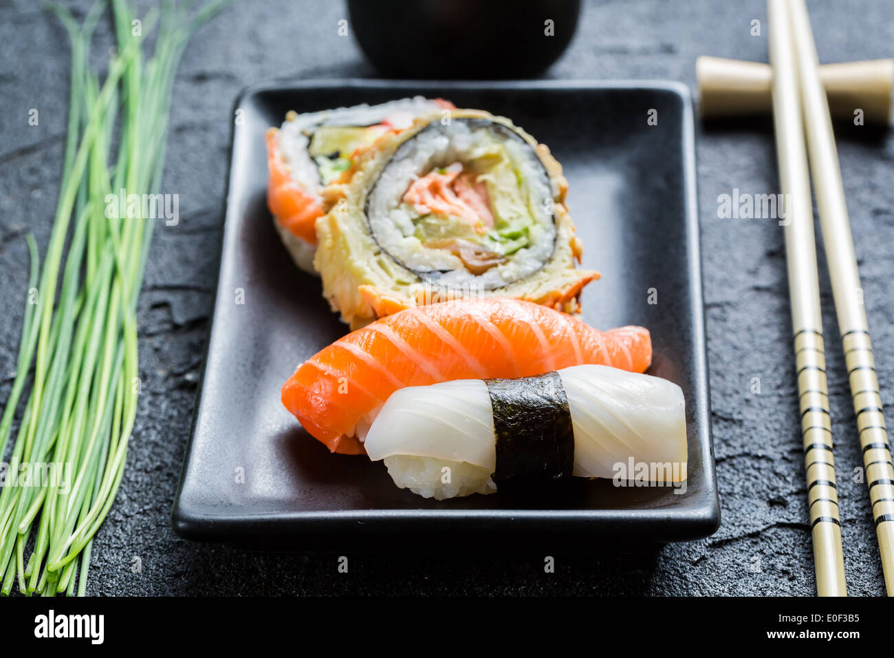 Closeup of fresh sushi, dark ceramic and chopstick Stock Photo