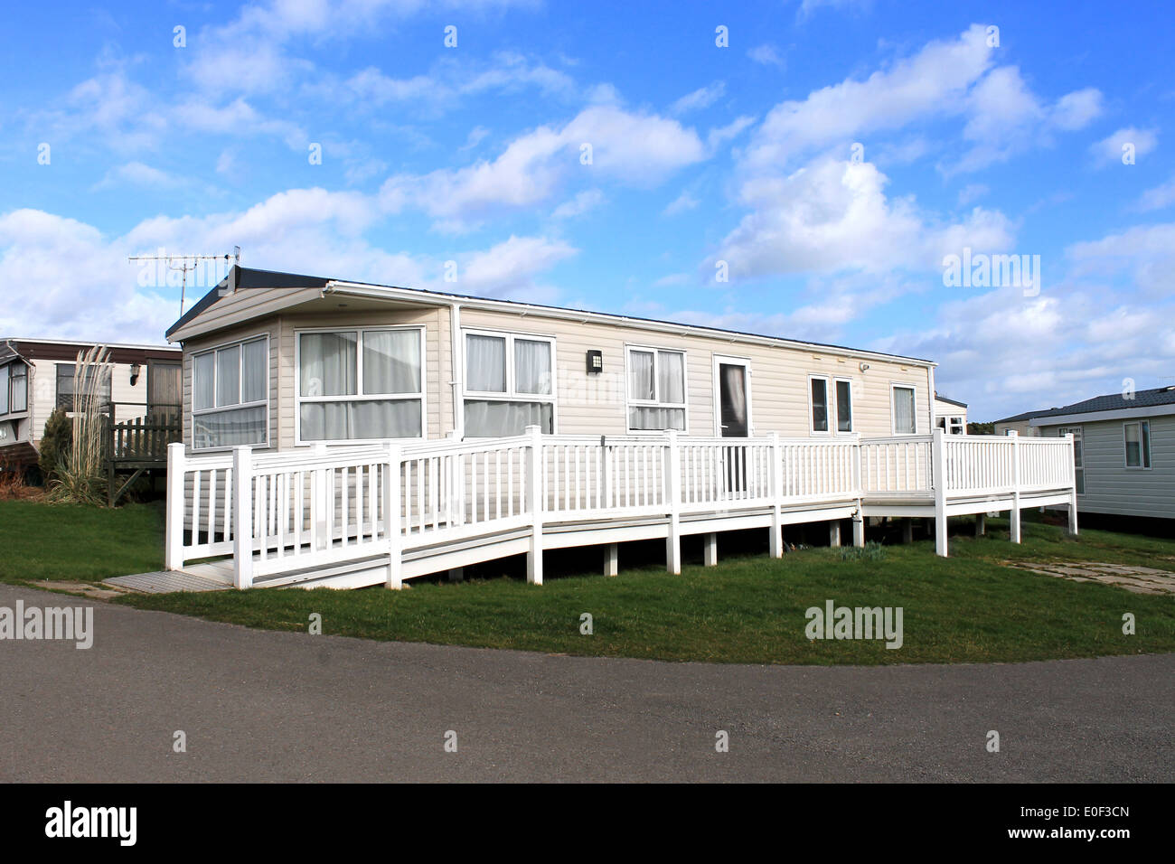 Side view of a caravan on a trailer park with a cloudscape background