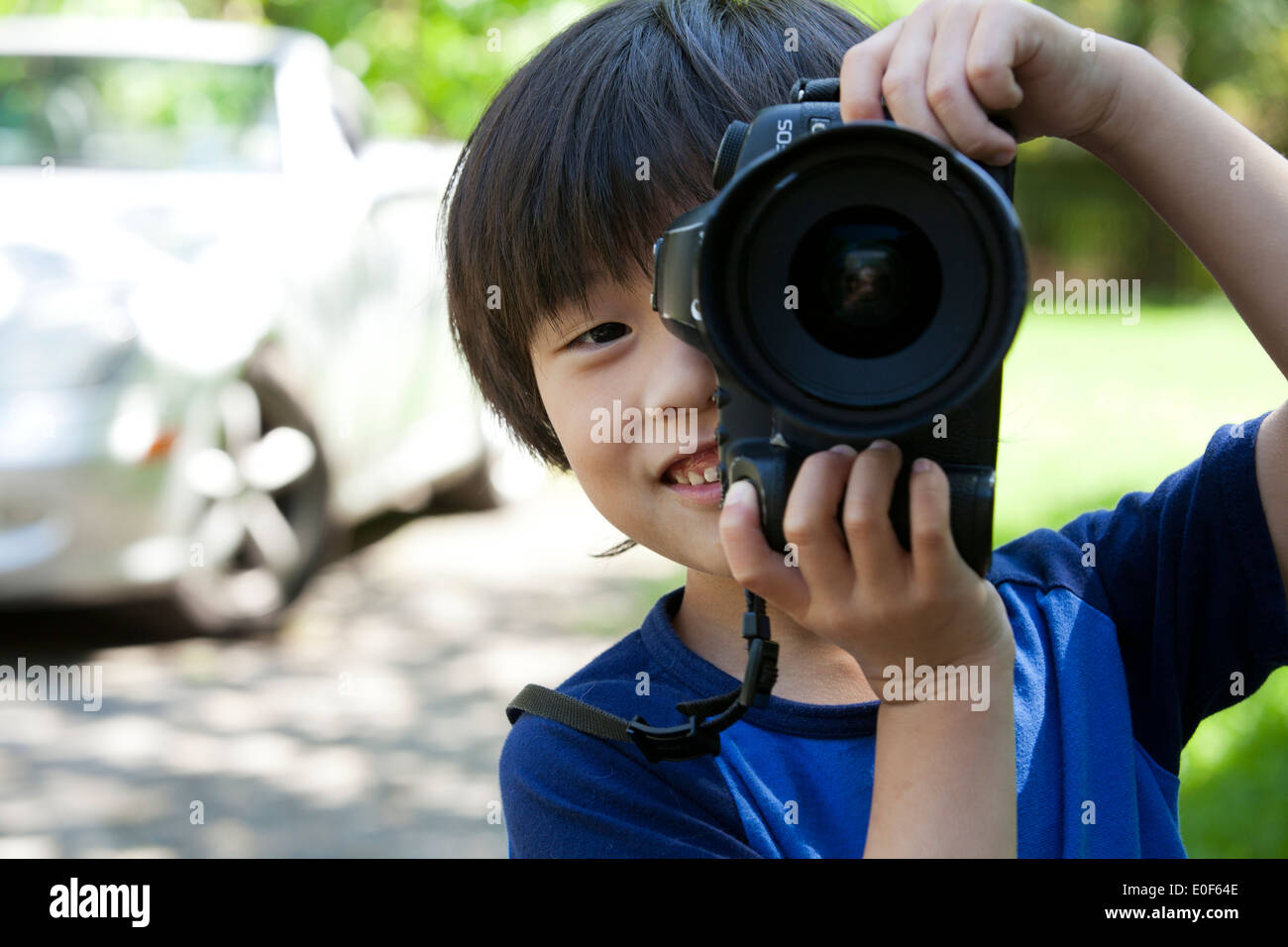 Child photographer, aged 5, using DSLR camera - USA Stock Photo