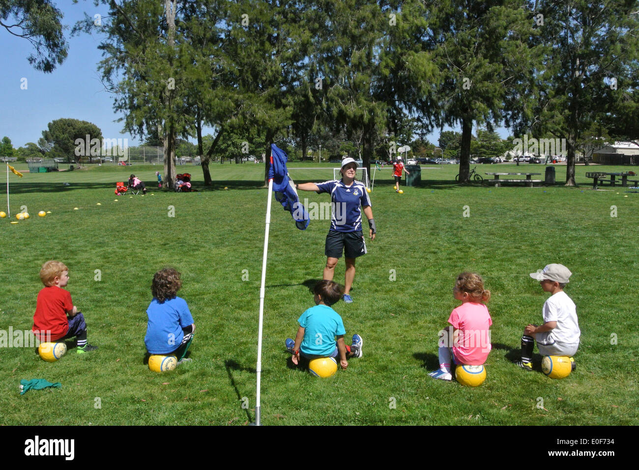 Children sitting soccer ball outdoors hires stock photography and